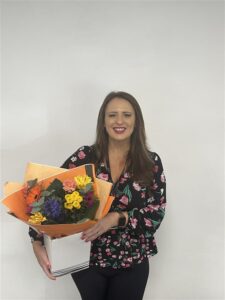 Margo holding flowers for her 20 years service